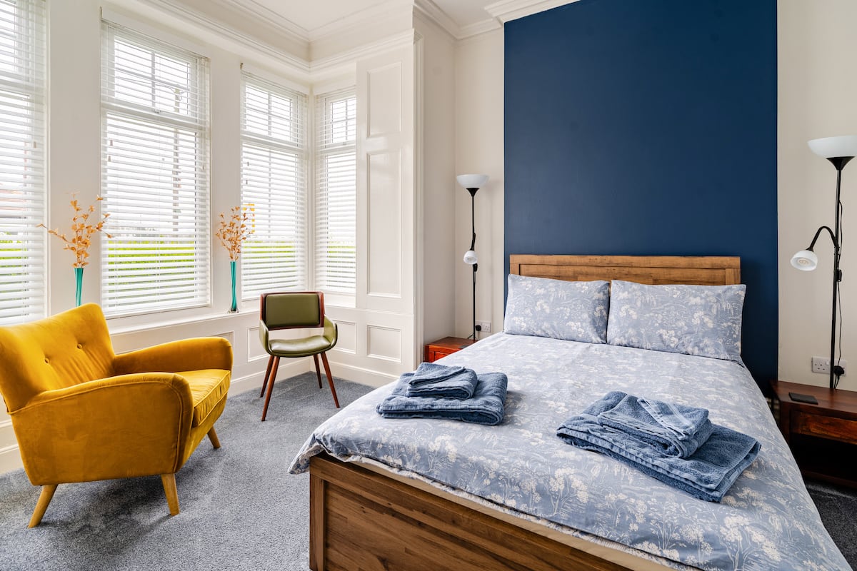 Cosy bedroom with navy accent wall and bay window at Seaham Stays
