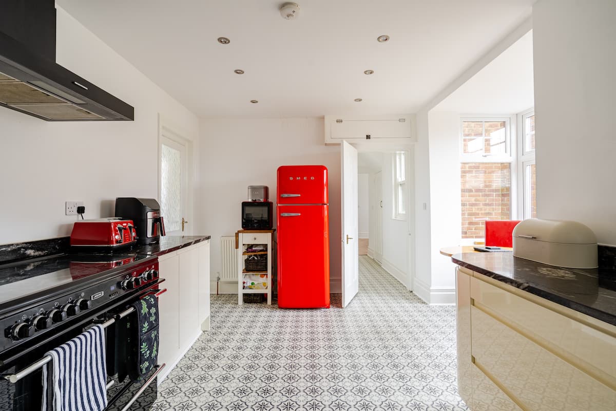 Fully equipped kitchen with range cooker and red SMEG fridge